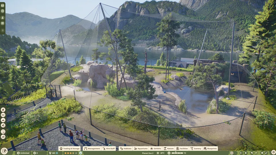 Aerial view of a large netted aviary habitat in a mountain valley in Planet Zoo 2